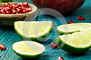 Ripe lime, pomegranate fruit on wooden vintage background.