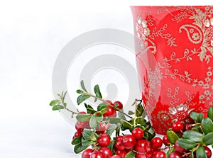 Ripe lingonberries and red cup with ornament