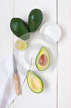 Ripe mellow cutted avocado on the white wooden table