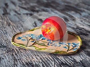 Ripe nectarine on a decorative plate with a pattern