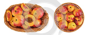 Ripe nectarine fruit with half in a wicker basket isolated on white background with full depth of field. Top view. Flat