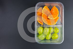 Ripe orange and green grape in the takeaway box