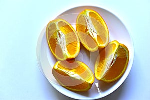 Ripe orange sliced on a white plate