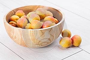 Ripe organic apricots fruits in ash tree wooden bowl