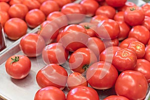 Ripe organic beefsteak tomatoes on metal tray at local market in Texas, America