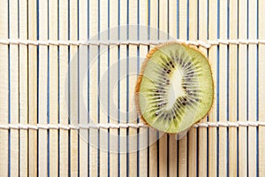 Ripe organic kiwi fruits on bamboo mat. Copy space. Chinese and japanese food concept. Top view