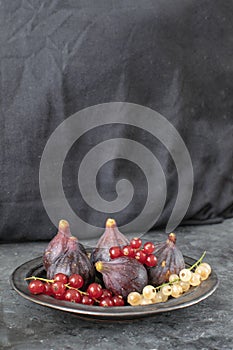 Ripe organic red and white currant Figs Ceramic plate Black background Still life Copy space Autumn harvest