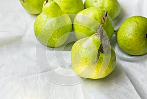 Ripe organic yellow green pears on white cotton table cloth in kitchens. Autumn fall harvest local bio produce vitamins