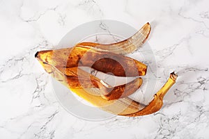 Ripe overripe organic banana peel on marble background. ugly food zero waste concept