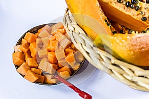 Ripe papaya in cane fruit basket on white background.