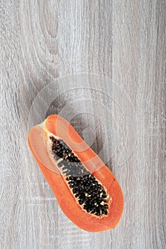 Ripe papaya with copyspace on wooden background.