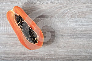 Ripe papaya with copyspace on wooden background.