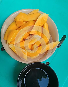 Slices of papaya fruit and vinegar souce in the table