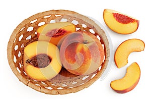 Ripe peach fruit with half in a wicker basket isolated on white background with full depth of field. Top view. Flat lay