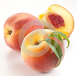 Ripe peach fruit with leaves and slises