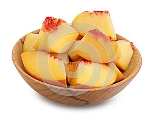 Ripe peach fruit slices in wooden bowl isolated on white background with clipping path and full depth of field