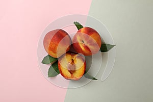 Ripe peach fruits with leaves on two tone background
