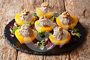 Ripe peach halves stuffed with canned tuna and walnuts, served w