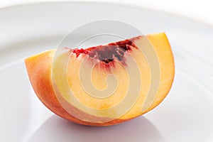 Ripe peach on the white plate, selective focus.