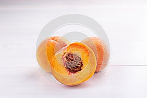 Ripe peaches close-up on a white wooden background