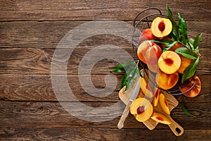 Ripe peaches with leaves in basket on wooden table