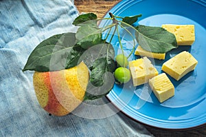 Ripe pear on a blue plate with a deep branch