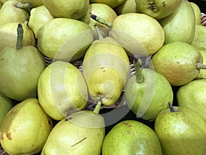 Ripe pears in a wicker basket on a market stall