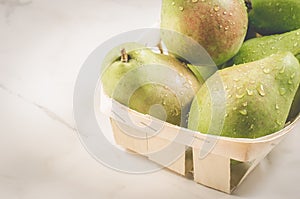 Ripe pears in a wooden box/ripe pears in a wooden box on a white marble background