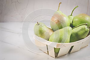 Ripe pears in a wooden box/ripe pears in a wooden box on a white marble table, selective focus and copyspace