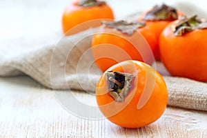 Ripe persimmon fruit on wooden table ready for eat