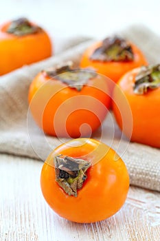 Ripe persimmon fruit on wooden table ready for eat