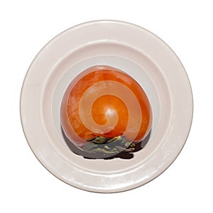 Ripe persimmon on a plate isolated on a white background.Persimmon is an exotic fruit with an original taste