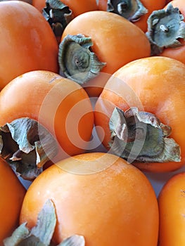 Ripe persimmons close-up. Fresh persimmons on the table.