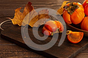 Ripe persimmons on a wooden background. Persimmon variety Fuyu