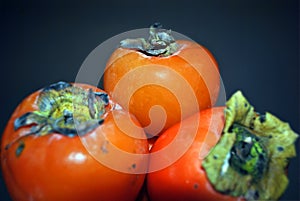 Ripe persimons on dark background