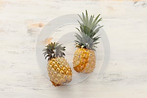 Ripe pineapple over white wooden background. Beach and tropical theme. Top view