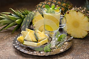 Ripe pineapples Ananas comosus and a glass