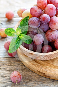 Ripe pink grapes in a wooden bowl.