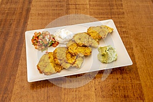 Ripe plantain patacon with dip sauces, guacamole, pico de gallo and cream cheese