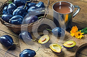 Ripe plums in a basket and plum juice