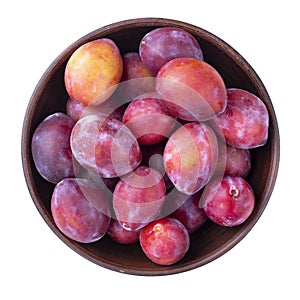 Ripe plums in a bowl isolated on white background. Top view. File contains clipping path
