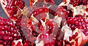 Ripe pomegranate on a dark wooden background. Slow motion.