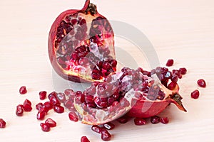 Ripe pomegranate fruit is cut on the table