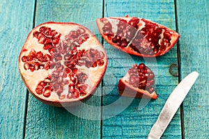 Ripe pomegranate fruit on wooden vintage background. Healthy vegetarian food.