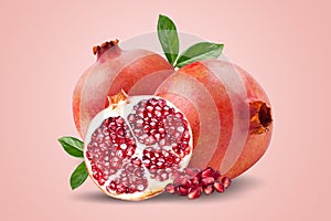 A ripe pomegranate with seeds and leaves. Background with pomegranate fruit. Pomegranate fruit on a pink background