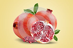 A ripe pomegranate with seeds and leaves. Background with pomegranate fruit. Pomegranate fruit on a yellow background