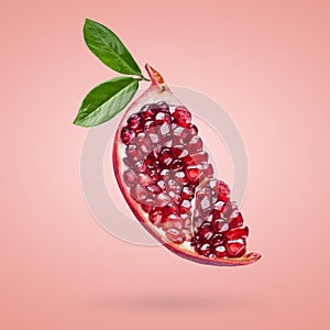 A ripe pomegranate with seeds and leaves flying in the air. Background with pomegranate fruit.