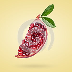 A ripe pomegranate with seeds and leaves flying in the air. Background with pomegranate fruit.