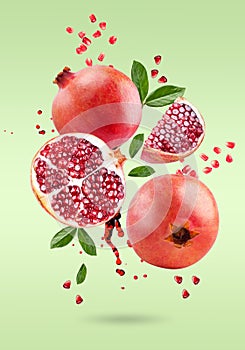 A ripe pomegranate with seeds and leaves flying in the air. Background with pomegranate fruit.