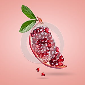 A ripe pomegranate with seeds and leaves flying in the air. Background with pomegranate fruit.